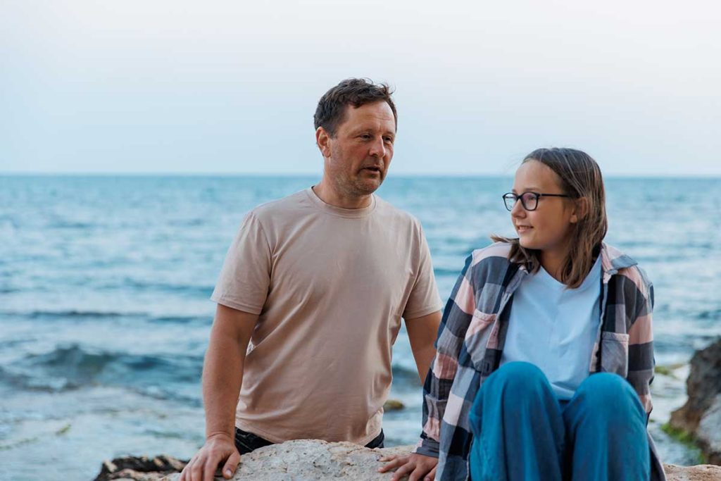 dad and daughter by sea discussing parenting issues